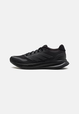 Chaussure de course noire basse avec lacets et trois bandes latérales, dotée d'une semelle texturée et d'une tige en mesh respirant.