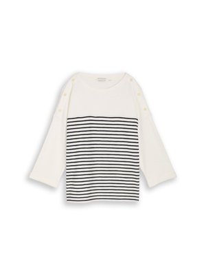 Chemise blanche à manches longues avec des rayures horizontales noires sur le bas de l'avant et des boutons le long des coutures des épaules.