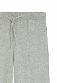 Helle graue Jogginghose aus weichem Stoff, mit einer Kordelzug taille, seitlichen Taschen und einer leicht strukturierten Oberfläche.