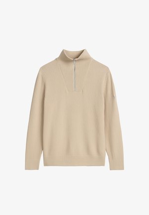 Beiger gerippter Strickpullover mit langen Ärmeln und kurzem silbernem Reißverschluss am hohen Kragen.