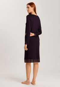 Abito a maniche lunghe, lungo fino al ginocchio, di un intenso colore viola, con orlo trasparente a righe e veste attillata, realizzato in un tessuto morbido e liscio.