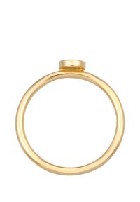 Anillo de oro con una banda lisa y redondeada y un pequeño detalle en la parte superior plana. La superficie es brillante y metálica con un color uniforme.