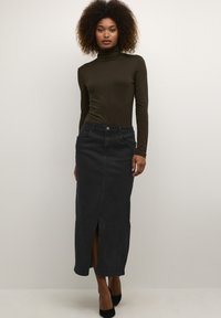 Black denim maxi skirt with front slit, paired with a dark green turtleneck top. Simple design, smooth texture, and tailored fit.
