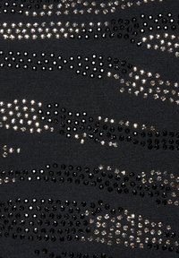 Schwarzer Stoff mit glänzenden Pailletten, die in verschiedenen Mustern und Texturen angeordnet sind und einen auffälligen visuellen Effekt mit metallischen Akzenten erzeugen.