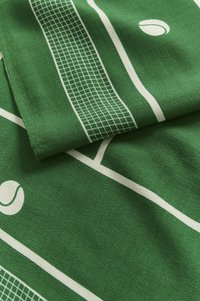 Tessuto verde a tema tennis con linee di campo bianche e motivi di palline da tennis, caratterizzato da una consistenza liscia e un materiale morbido.
