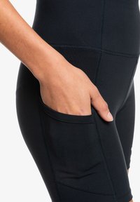Svarta träningsshorts med en sidficka, tillverkade av stretchigt, ventilerande tyg med platta sömmar för komfort.