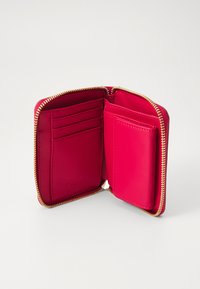 Portafoglio in pelle rossa con chiusura a zip, dotato di sei slot per carte e una tasca trasparente per l'ID. Texture liscia con una cerniera dorata a contrasto.