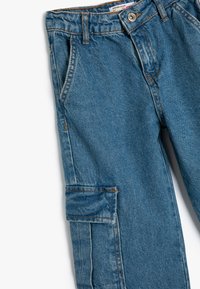 Pantalones cargo de mezclilla azul con un corte clásico, que presentan bolsillos laterales, costuras en contraste y un cierre de botón en la cintura.