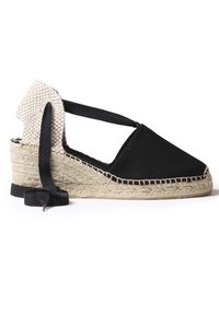 Espadrilla nera in tela con tacco intrecciato beige, dotata di cinturini incrociati e suola in corda di juta. Il design è semplice e piatto.