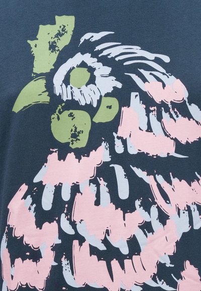 Μπλε ύφασμα με σχεδιασμό πουλιού σε ροζ, λευκό και πράσινο. Το πουλί έχει έντονες πινελιές και υφή με υφασμάτινη  όψη.