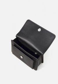 Schwarze Lederbörse mit strukturiertem Finish, ausgestattet mit einem silbernen Druckknopfverschluss, einer inneren Reißverschlusstasche und mehreren Kartenfächern. Offene Ansicht.