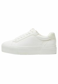 Baskets blanches en matériau synthétique lisse avec un bout rond, une semelle en caoutchouc plate et des détails de couture discrets. Laçage sur le devant.