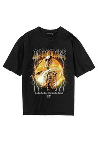 Sorte bomulds T-shirt med et skeletgrafik, som har et kranium, lyn og tekst. Frontdesignet inkluderer orange og gule flammer.