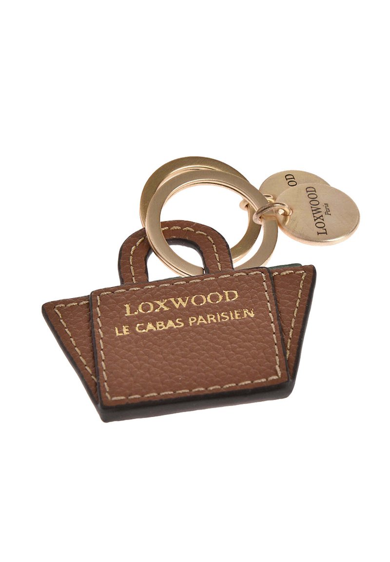 Porte-clés en cuir brun en forme de sac fourre-tout, avec le texte doré "LOXWOOD," et une bague en métal doré avec une étiquette attachée.
