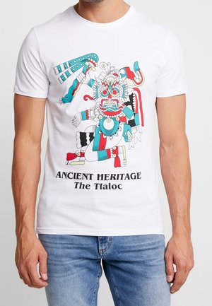 T-shirt en coton blanc avec un imprimé graphique coloré de Tlaloc, présentant des détails complexes et le texte "Héritage Ancien Le Tlaloc."