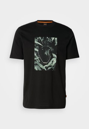 Čierne bavlnené tričko s krátkymi rukávmi, ktoré zobrazuje centrálny grafický motív pantera obklopeného listami, so špirálovým golierom a textom "BOSS".