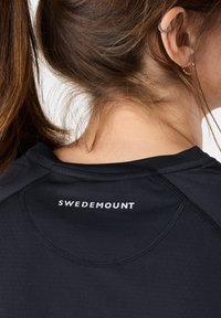 Zwarte sporttop met een ronde halslijn, met de tekst "SWEDEMOUNT" in het wit op de rug. Soepele textuur met subtiele naaddetails.