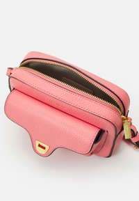 Borsa a tracolla in pelle rosa con effetto graniglia, zip dorata, bordi a contrasto e tasca frontale. Dotata di tracolla regolabile e accessori in metallo.