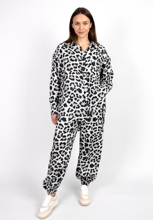 Black and white leopard print loungewear set with a long-sleeve button-up shirt and elasticated cuff pants, made of soft fabric.