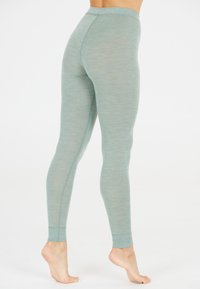 Lichtgroene leggings van een zachte, rekbare stof, met een hoge tailleband en taps toelopende benen, een gladde textuur en minimale naden.