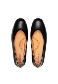 Ballerines en cuir noir avec une semelle intérieure beige, bout rond et texture lisse. Détail de couture notable le long du bord. Logo de la marque visible.