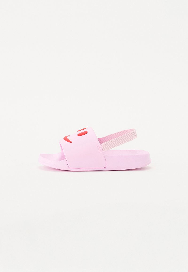 Vaaleanpunaiset liukuvarvastossut, joissa on leveä hihna, jossa on hymyilevän kasvokuvan grafiikka, teksturoitu kumipohja ja elastinen takahihna turvallista istuvuutta varten.