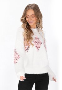 Weißer Strickpullover mit rautenförmigen Mustern in Rot und Schwarz, entspannter Schnitt und markante, strukturierte Ärmel.