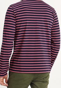 Long-sleeve shirt with navy and pink horizontal stripes, made of soft fabric, featuring a crew neck and a relaxed fit.