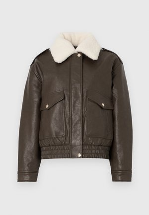 Rjava usnjena jakna s kremnim ovratnikom iz ovčjega krzna, velikimi sprednjimi žepi, elastičnim robom in zlatimi kovinskimi dodatki. Klasična zasnova bomber jakne.