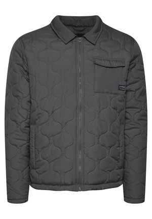 Chaqueta gris acolchada con cierre de cremallera en la parte delantera, cuello tipo solapa y bolsillo en el pecho. Presenta una textura suave y un patrón redondeado en la tela.