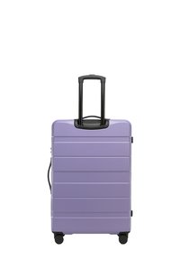 Valise rigide violet clair avec un design texturé à rainures, deux roues noires et une poignée rétractable noire.