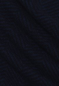 Dunkelblaues Wollgewebe mit Fischgrätmuster, das eine weiche Textur und subtile Farbvariationen aufweist, in Wellen gefaltet.