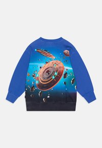 Modrá mikina s vesmírnou scénou na zadní straně, která zobrazuje tři futuristické létající talíře a plovoucí asteroidy na zářícím modrém pozadí.