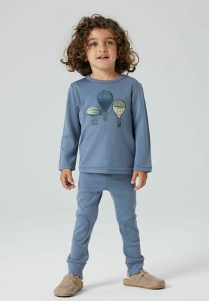 Blaues Baumwoll-Loungewear-Set mit einem Motiv von Heißluftballons, langen Ärmeln, gerippten Bündchen und passenden engen Hosen mit Akzenten an den Knien.