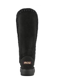 Stivale in suede nero con gambale alto, caratterizzato da cuciture decorative lungo il lato e una suola in gomma. Sul retro è presente una toppa con logo in colori tenui.