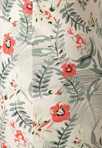 Motif de tissu floral avec des fleurs rouge corail, des feuilles grises et noires, et des accents vert clair sur un fond blanc.