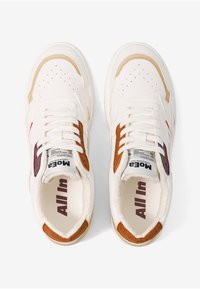 Witte sneakers met tan en bordeauxaccenten, met een gestructureerde zool, geperforeerd teengebied en een zachte binnenvoering. "ALL In" gedrukt aan de binnenkant.