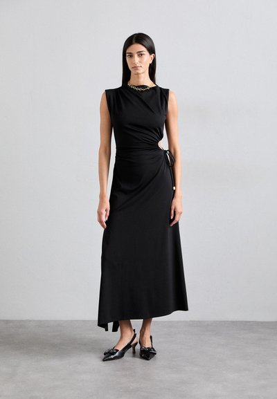 Rochie maxi neagră, fără mâneci, cu un design drapat și detalii cu nod lateral. Purtați cu pantofi cu toc slingback negri, cu vârful ascuțit și accesorii decorative.