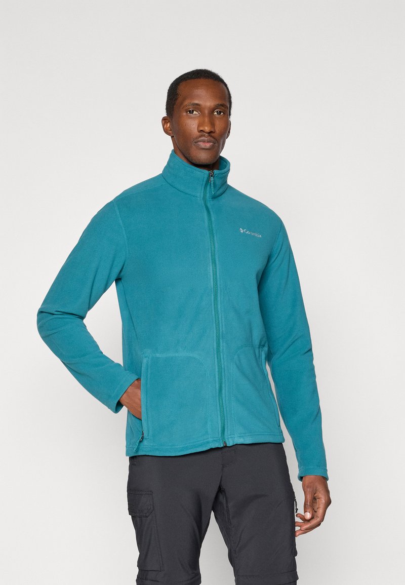 Turkusowa polarowa kurtka z wysokim kołnierzem, pełnym zamkiem i dwiema przednimi kieszeniami. Gładka tekstura i subtelne logo na klatce piersiowej.