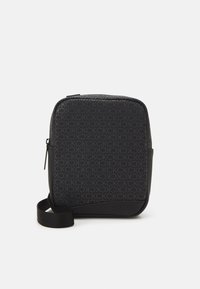Bolso bandolera negro con un patrón de logotipo en relieve que se repite, forma rectangular elegante y un acabado mate contrastante en la base.