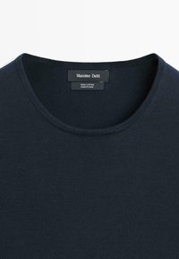 Dunkelblauer Baumwollpullover mit Rundhalsausschnitt und der Marke "Massimo Dutti" auf dem innen am Kragen eingenähten Etikett.
