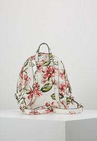 Rugzak met bloemmotief gemaakt van synthetisch materiaal, met roze bloemen en groene bladeren op een crème achtergrond; verstelbare banden.