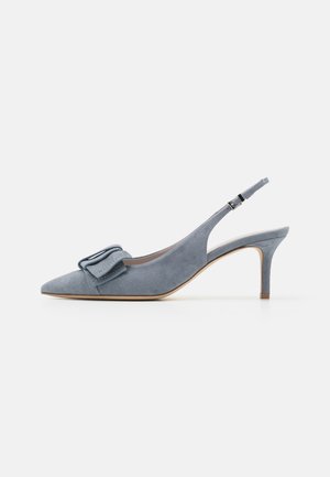 Tacón slingback de ante azul claro con punta puntiaguda, detalle de lazo en la parte frontal y tacón stiletto delgado. Superficie texturizada.