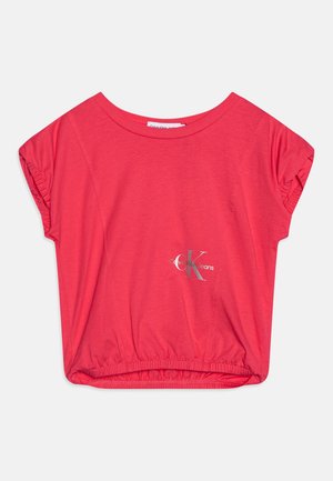 Short-sleeve, coral cropped top made of soft fabric, featuring an elastic hem and metallic Calvin Klein Jeans logo on the front.