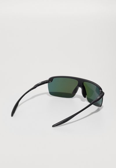 Lunettes noires avec des verres teintés verts. Elles possèdent une monture angulaire, des plaquettes de nez en caoutchouc et des branches fines et courbées. Détails texturés sur la monture.