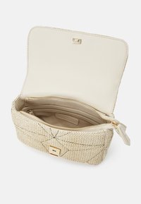 Włoszana kopertówka w kolorze beżowym z jasnobrązowym wnętrzem, wyposażona w zamek błyskawiczny i złote detale. Posiada kieszenie na karty oraz wewnętrzną kieszonkę.