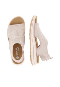 Light pink open-toe shoes with a woven texture, soft footbed, elastic side panels, and a small heel. White rubber outsole with grips.