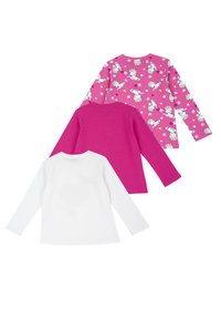 Tři trička s dlouhým rukávem: jedno bílé s vzorem srdíček, jedno jednobarevné růžové a jedno růžové potištěné jednorožci a hvězdami na jasném pozadí.