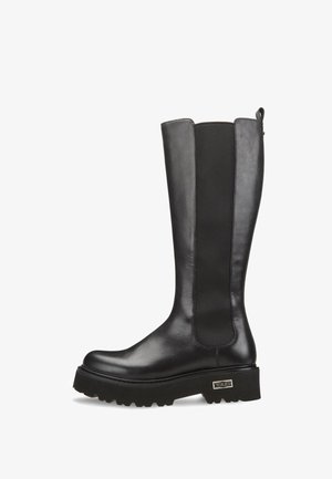 Stivali neri fino al ginocchio con finitura in pelle liscia, pannelli laterali elastici e suola spessa e texturizzata. Presentano un piccolo logo metallico come dettaglio.