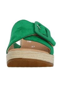 Sandali verdi in suede con una larga fascetta incrociata, un prominente dettaglio a fibbia e una suola piatta beige texturizzata. Taglia contrassegnata come 37.